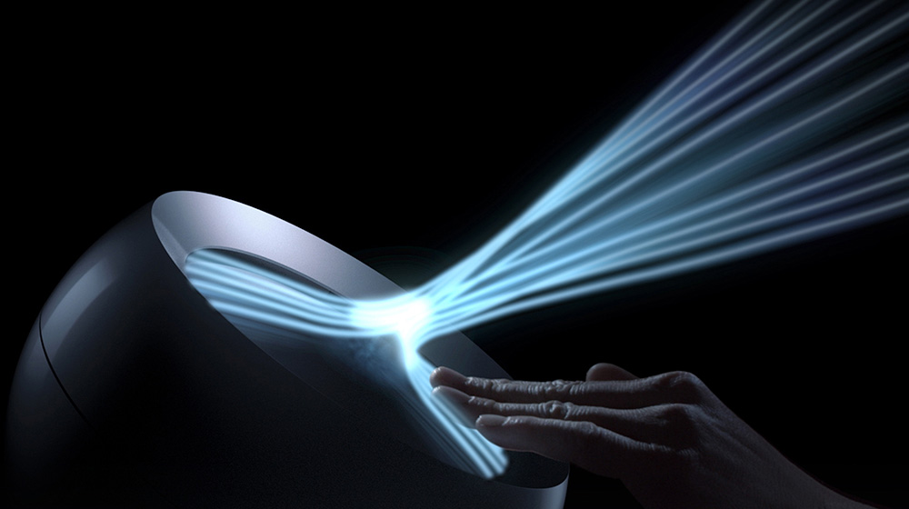 An office worker using a Dyson Pure Cool Me personal purifier fan